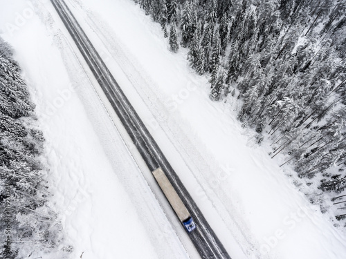 Fast driving semitrailer truck is on slippery winter asphalt highway, top view from drone © Kekyalyaynen