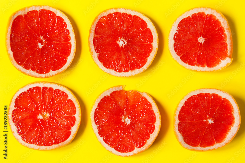 A circles of grapefruit on a bright yellow background. Concept background. Flat lay. A circles of grapefruit on a bright yellow background. Concept background. Flat lay.