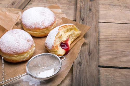 Traditional Polish donuts on wooden background. Tasty doughnuts with jam.