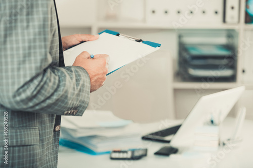 Man working in the office at the laptop with documents