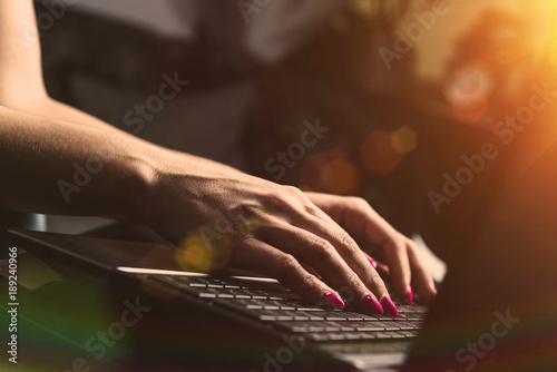 Woman working at home, typing on a laptop keyboard. Evening, hard work, catching up, work concept. The woman spends her free time on performing official duties.