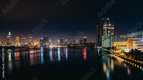 Urban night skyline panoramic view of Ho Chi Minh city. Front view on colored skyscrapers in downtown from the river