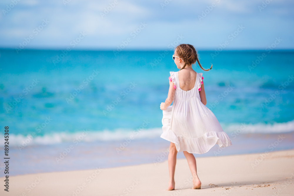 Cute little girl in white dress at beach during caribbean vacation Cute little girl in white dress at beach during caribbean vacation