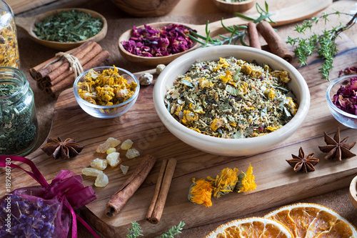 A mix of dried and fresh herbs on a wooden table