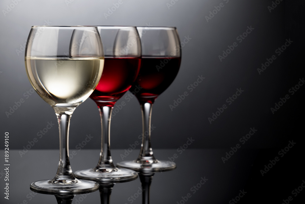 Elegant red, rose and white wine glasses in a black background Elegant red, rose and white wine glasses in a black background