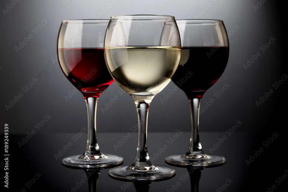 Red, rose and white wine glasses in a black background