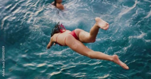 Beautiful young woman diving into the ocean