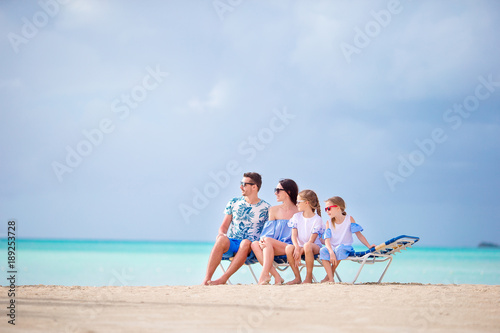 Young family on vacation at sunbeds on white beach © travnikovstudio