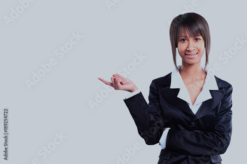 Business woman pointing at white background.