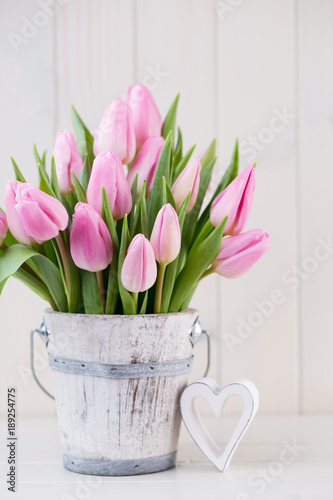 Spring easter tulips in bucket on white vintage background.