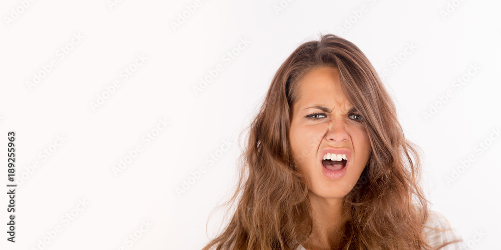 A frustrated and angry girl screaming; isolated on white, copy space photo A frustrated and angry girl screaming; isolated on white, copy space photo