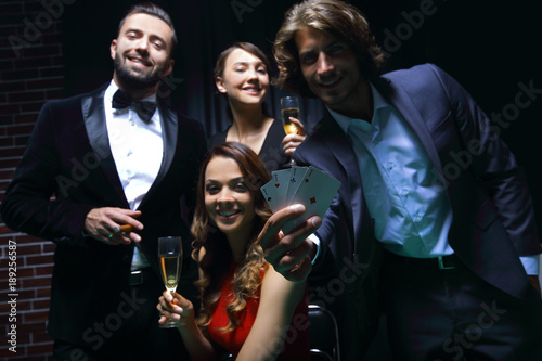Four people toasting with champagne at roulette in casino