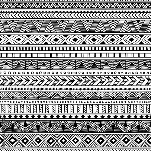 Seamless ethnic pattern. Black and white striped background. Aztec and tribal motifs. Prints for textiles.