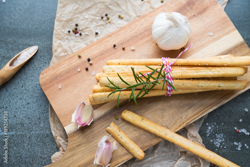 bread grissini with garlic and rosemary, sprinkled with salt on a stone table photo