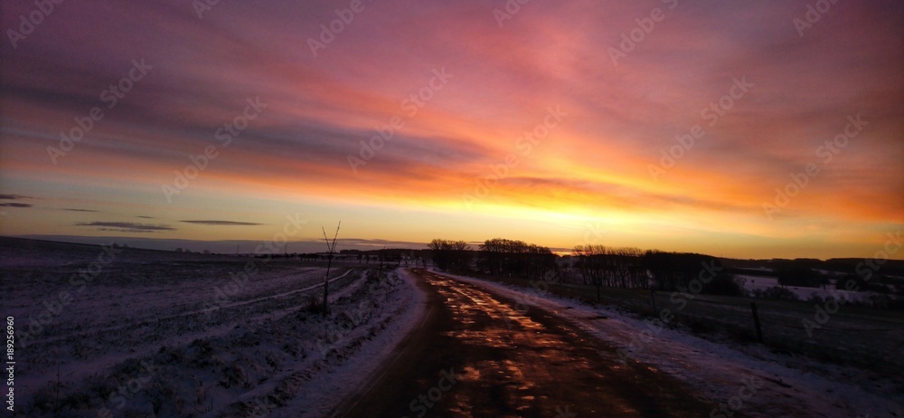 View on road during sunny morning with beautiful colorful sky.