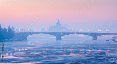 Panoramic view of Margaret bridge against Parliament outline in winter haze under pink sky
