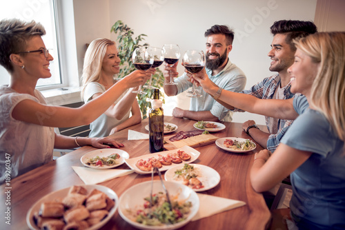 Young friends celebrate with alcohol and food