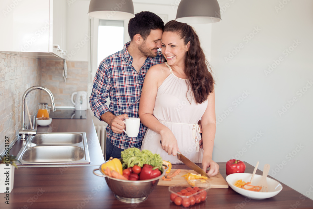 Loving couple cooking together in the kitchen.