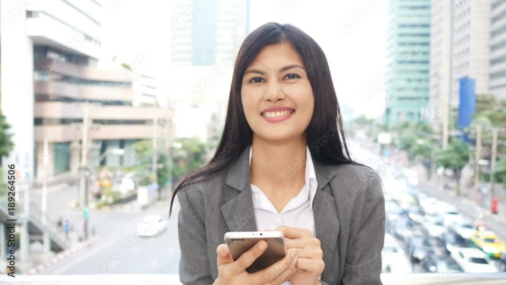 Asian woman using smartphone at city. Woman using smartphone with attractive smiling. People working concept. Asian woman using smartphone at city. Woman using smartphone with attractive smiling. People working concept.