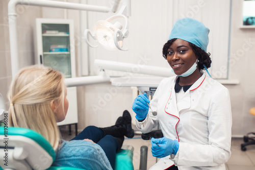 young black girl doctor dentist treats white girl s teeth