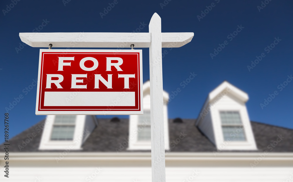 Left Facing For Rent Real Estate Sign In Front of House and Deep Blue Sky. Left Facing For Rent Real Estate Sign In Front of House and Deep Blue Sky.