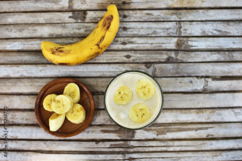 Healthy smoothie with banana on wooden background.