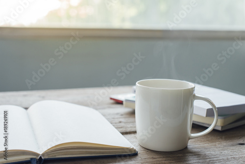 a cup of milk with notebook on the table