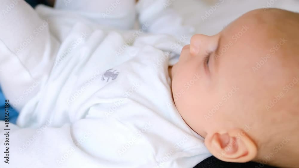 Smiling young mother holding baby on lap while playing on bed in the bedroom Smiling young mother holding baby on lap while playing on bed in the bedroom