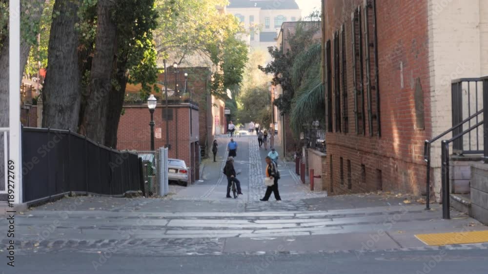 A man is riding a bike through a downtown alleyway. A man is riding a bike through a downtown alleyway.