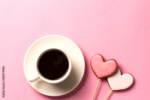 Valentine day background with gingerbread hearts and a cup of coffee, top view with space for your text