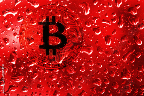 coin bitcoin behind glass with red drops. blood on bitcoin. terrorism, war, extortion, crimes for bitcoins. photo