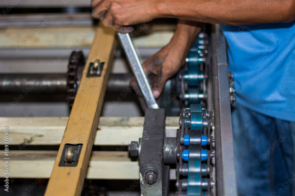 The technician repairing conveyor belt in factory The technician repairing conveyor belt in factory