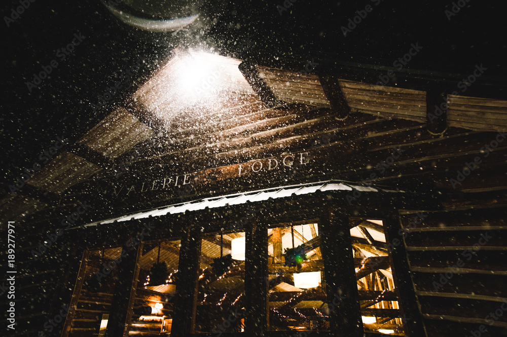 Snow Falls on Lodge at Night