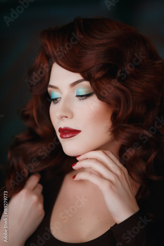 Portrait of beautiful redhead young girl with red lipstick. Concept person for a glossy magazine, model, eyes closed