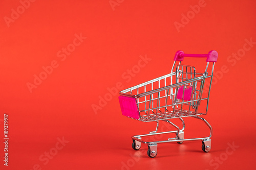 Shopping cart or supermarket trolley on red background, business finance shopping concept.