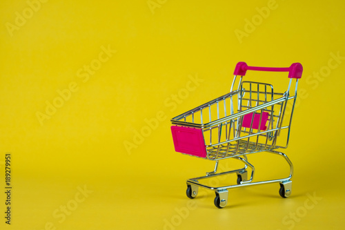 Shopping cart or supermarket trolley on yellow background, business finance shopping concept.