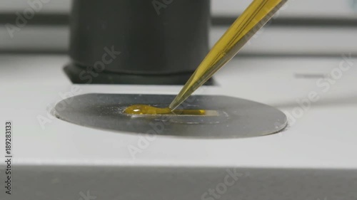 Macro Lab Pipette Puts Liquid Sample Drop on Glass photo