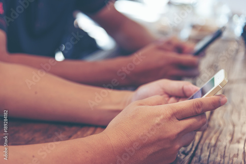 Selected focus on man hand, relaxed using smart phone and digital tablet at coffee shop. Young man browsing on smart phone in interior building. E-business internet of things concept. Freelance