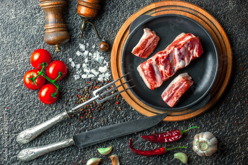 Raw meat on the kitchen table on a metallic background in a composition with cooking accessories