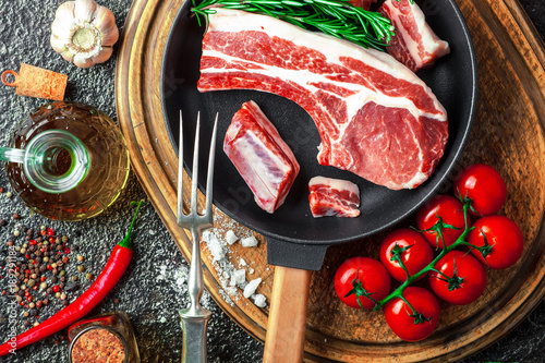 Raw meat on the kitchen table on a metallic background in a composition with cooking accessories photo