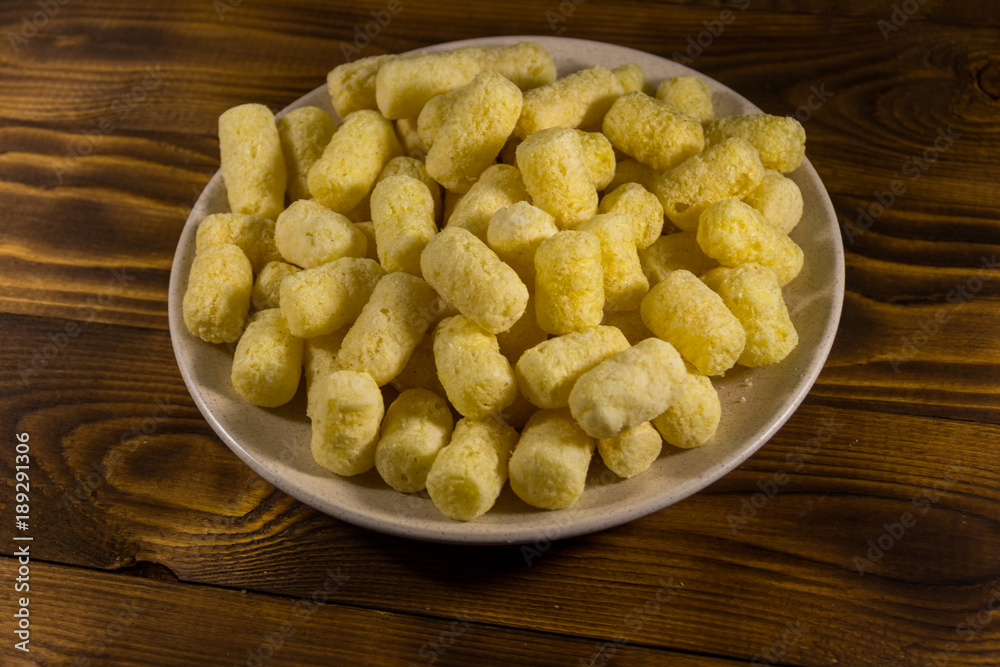 Sweet corn sticks on a plate on wooden table