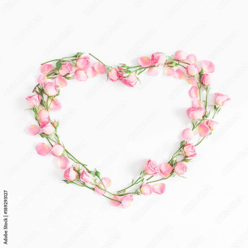 Flowers composition. Heart symbol made of pink rose flowers on white