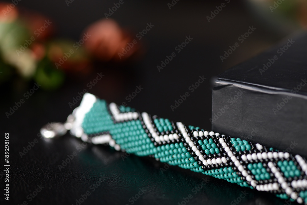 Green bead crochet bracelet with celtic print on a dark background close up Green bead crochet bracelet with celtic print on a dark background close up