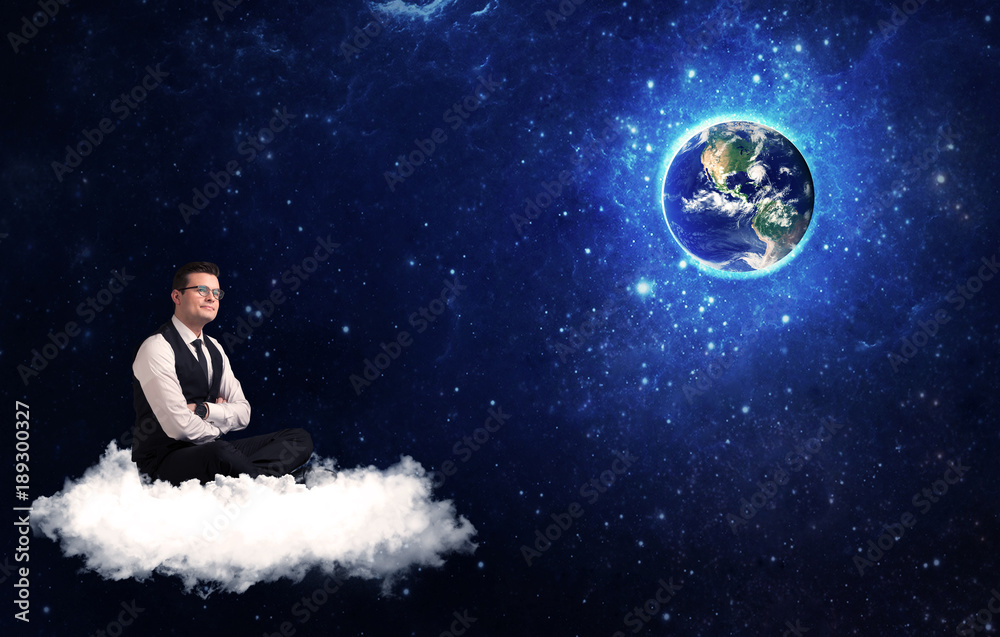 Naklejka premium Man sitting on cloud looking at planet earth