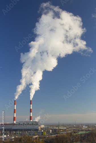 Smoke from industrial chimneys against the blue sky. Pollution.