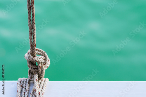 White steel with rope on ferry and sky blue ocean on background.Space for text or character on the right of picture.
