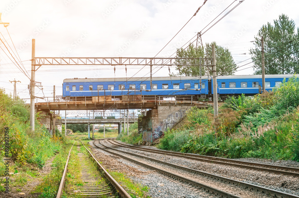 Train a passenger car drives along a railroad bridge through a friend railway. Train a passenger car drives along a railroad bridge through a friend railway.