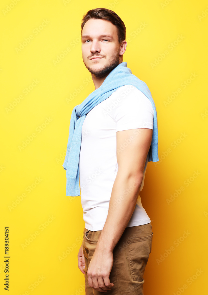 young man in smart casual wear looking at camera over yellow bac young man in smart casual wear looking at camera over yellow bac