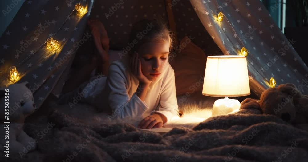 Girl reading book at night. Dolly shot Girl reading book at night. Dolly shot