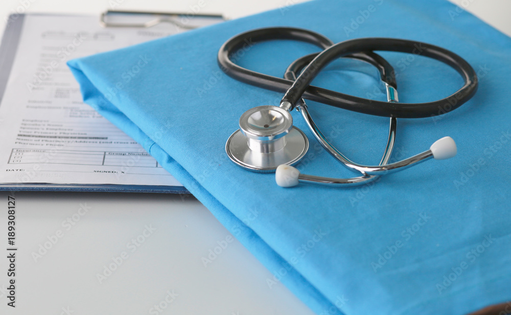 Stethoscope on a table with medical uniform Stethoscope on a table with medical uniform